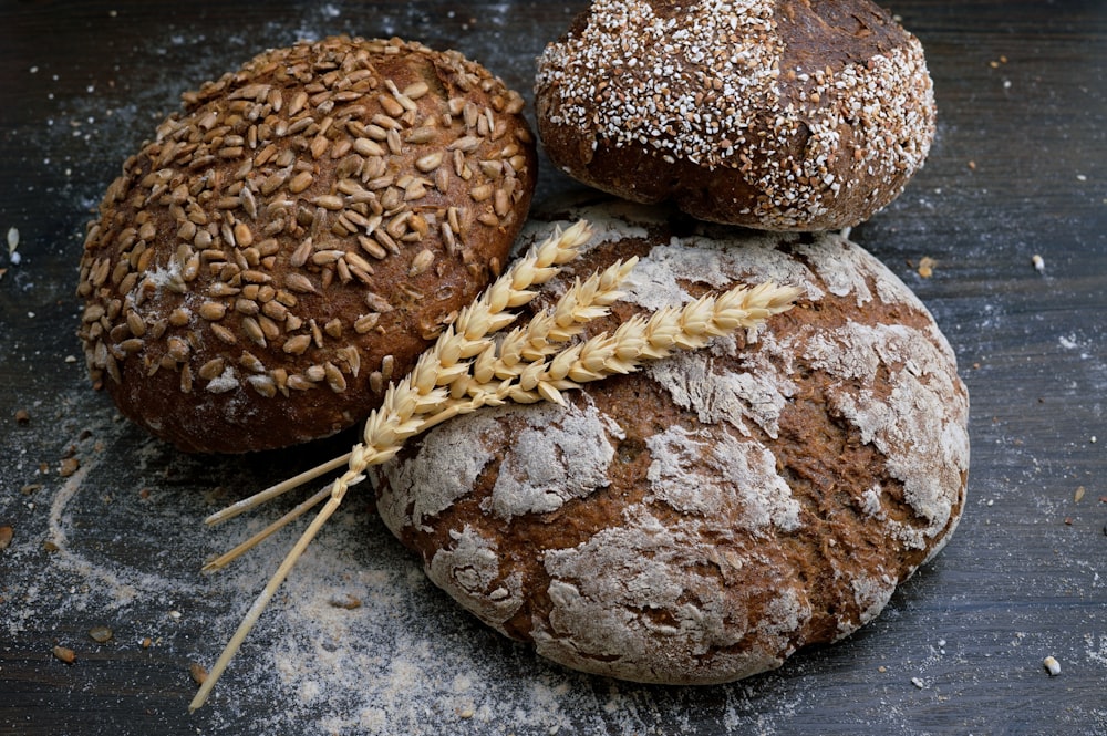 Seeded artisan bread loaves arranged on a dark bakery table