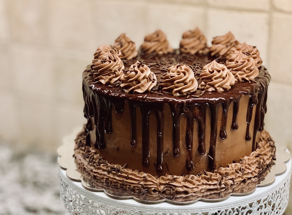Chocolate layer cake with piped frosting and glossy ganache